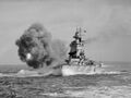 HMS Nelson firing her 16-inch (406 mm) guns during a practice shoot. The photo was taken just after firing and the effects of the compression wave are visible.
