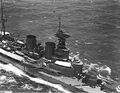 Aerial view of Hood in 1924. The two forward gun turrets are visible with their prominent rangefinders projecting from the rear of the turret. Behind the turret is the conning tower surmounted by the main fire-control director with its own rangefinder. The secondary director is mounted on top of the spotting top on the tripod foremast.